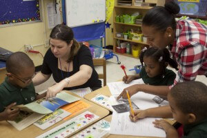 Teacher Sheri McCormick (left) and paraprofessional Shashala Saulsbury work on a reading assignment with students.
Credit: UFT
